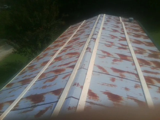Rusted metal roof panels with new wood purlins before replacement — Storm Damage Roof Repair in Alto by Roofing Brothers