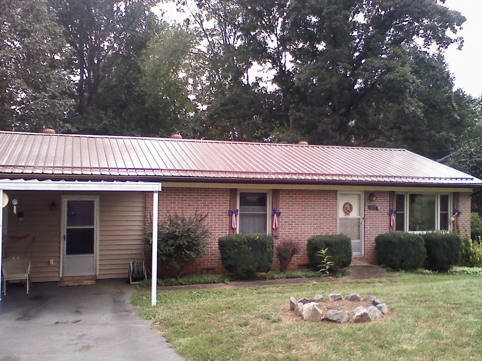 Bronze metal roof and carport on a brick ranch home — Roof Repair work by our crew in Alto