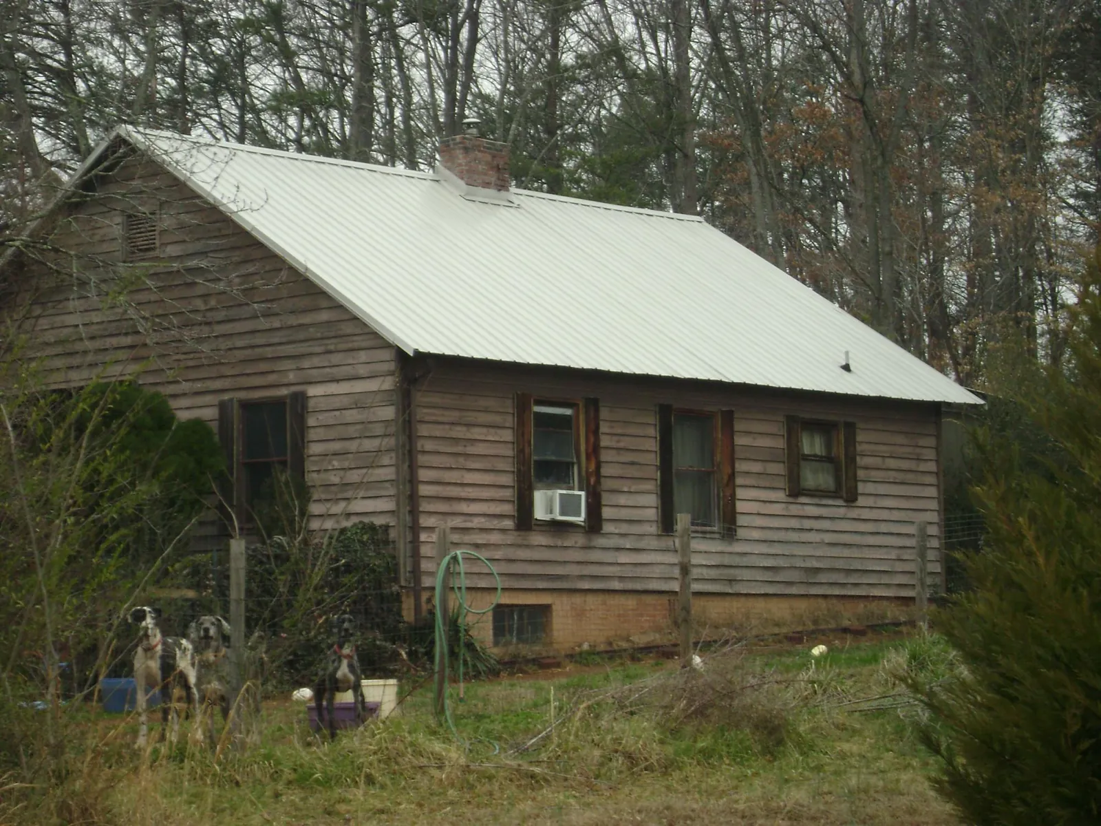 White metal roof on an old wood sided farmhouse, from a Metal Roof Installation job in Alto